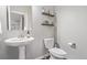 Cozy powder room featuring a pedestal sink, toilet, and decorative shelving at 11250 Florence St # 30B, Commerce City, CO 80640