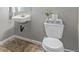 Quaint powder room with a pedestal sink, a toilet with playful decor, and neutral tones that offer a fresh, clean look at 11250 Florence St # 30B, Commerce City, CO 80640