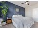 Bedroom featuring a gray and white bed, a wooden nightstand, and a blue accent wall at 11250 Florence St # 30B, Commerce City, CO 80640