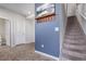Inviting entryway with gray walls, decorative wall art, coat hooks and a carpeted staircase leading to the upper level at 11250 Florence St # 30B, Commerce City, CO 80640