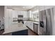 Well-lit kitchen featuring stainless steel appliances, sleek white cabinetry, and a functional kitchen island at 11250 Florence St # 30B, Commerce City, CO 80640