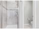 Tiled shower with glass door and showerhead, adjacent to the toilet and powder room at 11250 Florence St # 30B, Commerce City, CO 80640