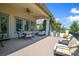 Relaxing covered patio with comfortable seating and views of the landscaped backyard at 26 Royal Ann Dr, Greenwood Village, CO 80111