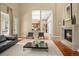 Open-concept living room featuring a fireplace, sleek furniture, and seamless flow to the kitchen area at 26 Royal Ann Dr, Greenwood Village, CO 80111