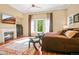 Spacious main bedroom featuring a cozy fireplace, sitting area, and large window for natural light at 26 Royal Ann Dr, Greenwood Village, CO 80111