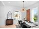 Elegant dining room features a brick accent wall, hardwood floors, and a modern chandelier at 2515 Zenobia St, Denver, CO 80212