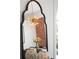 Stylish dining room mirror reflecting a brick wall, a modern light fixture, and elegant table setting at 2515 Zenobia St, Denver, CO 80212