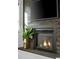 Close-up of a modern fireplace featuring a wood accent wall and a mounted television screen at 2515 Zenobia St, Denver, CO 80212