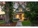 Inviting home featuring a brick facade, a covered porch, and mature trees in the front yard at 2515 Zenobia St, Denver, CO 80212