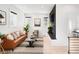 Cozy living room featuring a leather sofa, decorative pillows, and a modern fireplace with a wood accent wall at 2515 Zenobia St, Denver, CO 80212