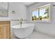 Elegant bathroom showcasing a modern tub, stylish fixtures, and bright natural light from the window at 300 S Franklin St, Denver, CO 80209