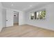 Bright bedroom with light hardwood floors, large windows, and a door to the bathroom at 300 S Franklin St, Denver, CO 80209