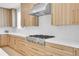 Kitchen featuring stainless steel gas range, white subway tile backsplash, and light wood cabinets at 300 S Franklin St, Denver, CO 80209