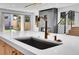 Modern kitchen with a stainless steel sink, white countertop, and view of the backyard at 300 S Franklin St, Denver, CO 80209
