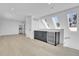 Open living room with light wood floors, skylights, and a sleek wet bar with wine refrigerator at 300 S Franklin St, Denver, CO 80209