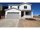 Charming two-story home featuring a covered porch, a gray garage door, and stone veneer accents at 24799 E 39Th Ave, Aurora, CO 80019