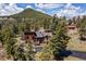 Aerial view of a home nestled among lush trees with mountain views at 8453 S Scenic Dr, Morrison, CO 80465