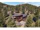 Stunning aerial view of a brown house nestled among lush green trees, offering both privacy and scenic beauty at 8453 S Scenic Dr, Morrison, CO 80465