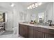 Modern bathroom with dual sinks, a shower with glass door, and marble counters at 8453 S Scenic Dr, Morrison, CO 80465