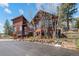 Exterior of a multi-level wood home with mature trees and well-manicured landscaping at 8453 S Scenic Dr, Morrison, CO 80465