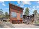 Stylish home with wood and stone exterior, large windows, and a spacious deck at 8453 S Scenic Dr, Morrison, CO 80465