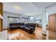 Open basement area with a large leather sofa, hardwood floors, a fireplace, and natural light from street-level windows at 6464 S Swadley Way, Littleton, CO 80127