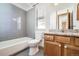 Bright bathroom featuring gray subway tiles, white fixtures, and modern vanity with granite countertops at 6464 S Swadley Way, Littleton, CO 80127