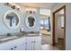 Bright bathroom featuring double sinks with granite countertops and modern fixtures at 6464 S Swadley Way, Littleton, CO 80127