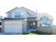 Charming two-story home featuring a two-car garage, brick accents, and manicured lawn, with a large front window at 6464 S Swadley Way, Littleton, CO 80127