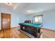 Spacious game room featuring a pool table, hardwood floors, and natural light from the window at 6464 S Swadley Way, Littleton, CO 80127