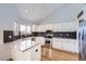 Well-lit kitchen with white cabinets, granite countertops, stainless steel appliances, and an undermount sink at 6464 S Swadley Way, Littleton, CO 80127