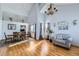 Living room with a vaulted ceiling, natural light, hardwood floors, contemporary furnishings, and an open dining area at 6464 S Swadley Way, Littleton, CO 80127