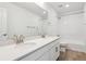 Bright bathroom featuring double sinks with white countertops, a shower over the tub, and wood look flooring at 24788 E 40Th Ave, Aurora, CO 80019