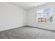 A bright bedroom with neutral walls and carpet with a large window offering views of the neighborhood at 24788 E 40Th Ave, Aurora, CO 80019