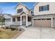 Charming two-story home featuring a covered porch, two-car garage and a combination of stone and siding exterior at 24788 E 40Th Ave, Aurora, CO 80019