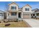 Charming two-story home featuring a covered porch, two-car garage and a combination of stone and siding exterior at 24788 E 40Th Ave, Aurora, CO 80019