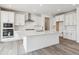 Modern kitchen features white cabinets, stainless steel appliances, large center island, and subway tile backsplash at 24788 E 40Th Ave, Aurora, CO 80019