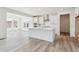 Modern kitchen with white cabinets, a large island, stainless steel appliances and light wood-look flooring at 24788 E 40Th Ave, Aurora, CO 80019