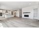 Open-concept living room features modern fireplace, built-in shelving, and luxury vinyl plank flooring at 24788 E 40Th Ave, Aurora, CO 80019