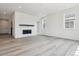 Bright living room features a fireplace with a dark wood mantel, built-in shelving, and large windows at 24788 E 40Th Ave, Aurora, CO 80019