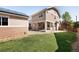 A home backyard with a small solar panel structure, green grass, and a rock bed at 2161 Willow Ct, Denver, CO 80238
