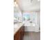 Bright bathroom featuring granite countertops, shower, and soaking tub with a window at 2161 Willow Ct, Denver, CO 80238