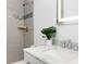 Beautiful bathroom featuring a sleek vanity with marble countertop, a modern illuminated mirror, and updated tile shower at 2161 Willow Ct, Denver, CO 80238