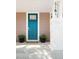 Close-up of a stylish blue front door with sidelights, potted plants, and a welcoming entrance at 2161 Willow Ct, Denver, CO 80238
