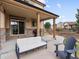 Covered back patio with a large glass door and two gray chairs and a white couch at 2463 Tavern Way, Castle Rock, CO 80104