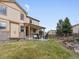 Lovely backyard features a covered patio, lush lawn, and meticulously designed landscaping at 2463 Tavern Way, Castle Rock, CO 80104