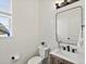 Modern powder room with tile walls, a decorative mirror, and vanity with stylish fixtures at 2463 Tavern Way, Castle Rock, CO 80104