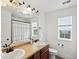 Bright bathroom with double sink vanity, framed mirror, and window at 2463 Tavern Way, Castle Rock, CO 80104