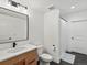 Modern bathroom featuring a wood vanity, black hardware, and a shower with patterned tile at 2463 Tavern Way, Castle Rock, CO 80104