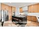 Modern kitchen featuring stainless steel appliances, light wood cabinets, and a striking black island with seating at 2463 Tavern Way, Castle Rock, CO 80104